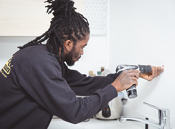 Handyman installing a shelf in a South London property