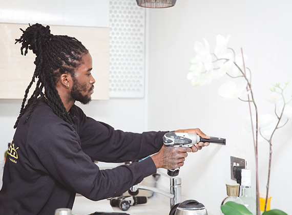 Handyman installing a shelf in a South London house